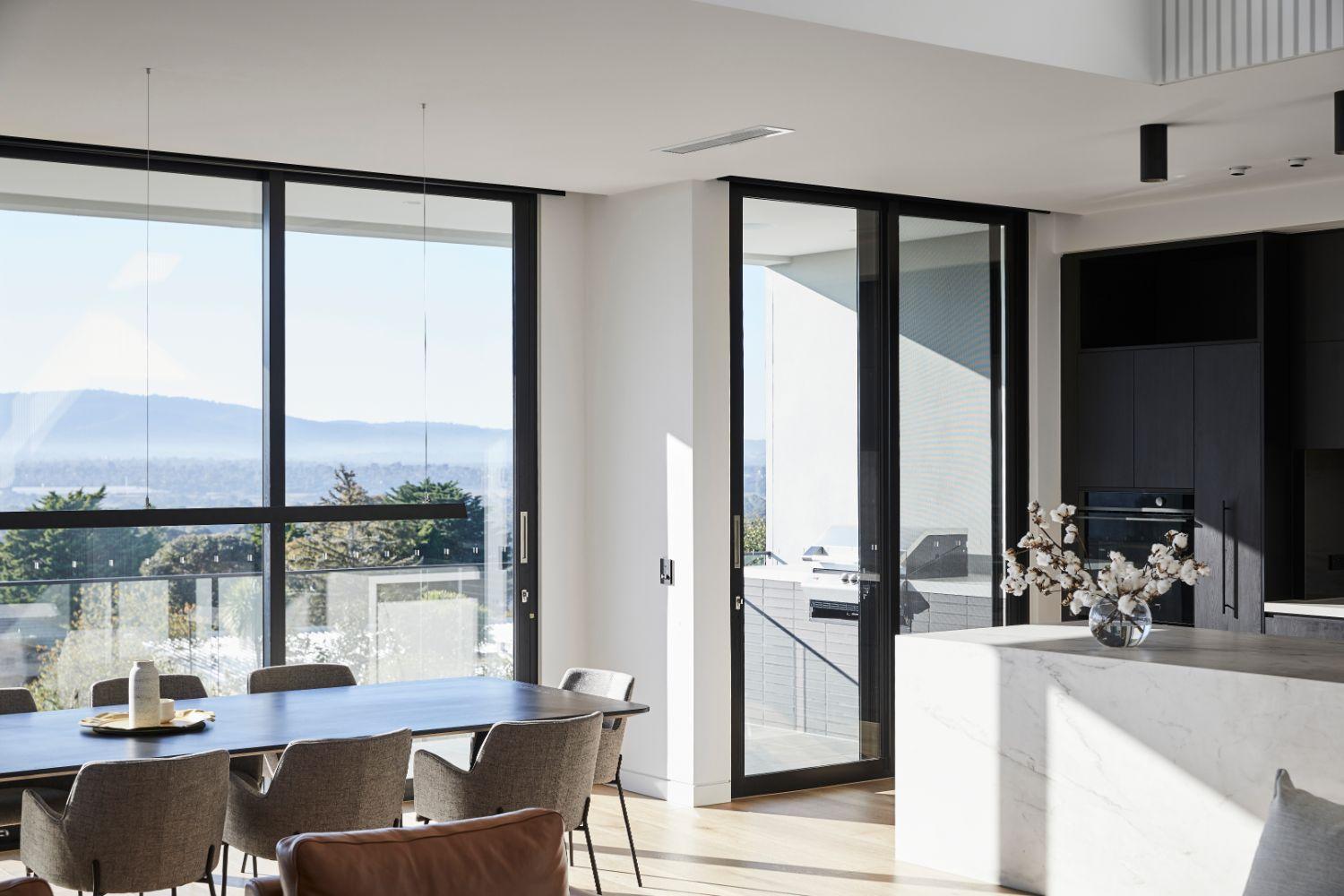 Full Length Windows And Door Illuminate Kitchen And Dining Area