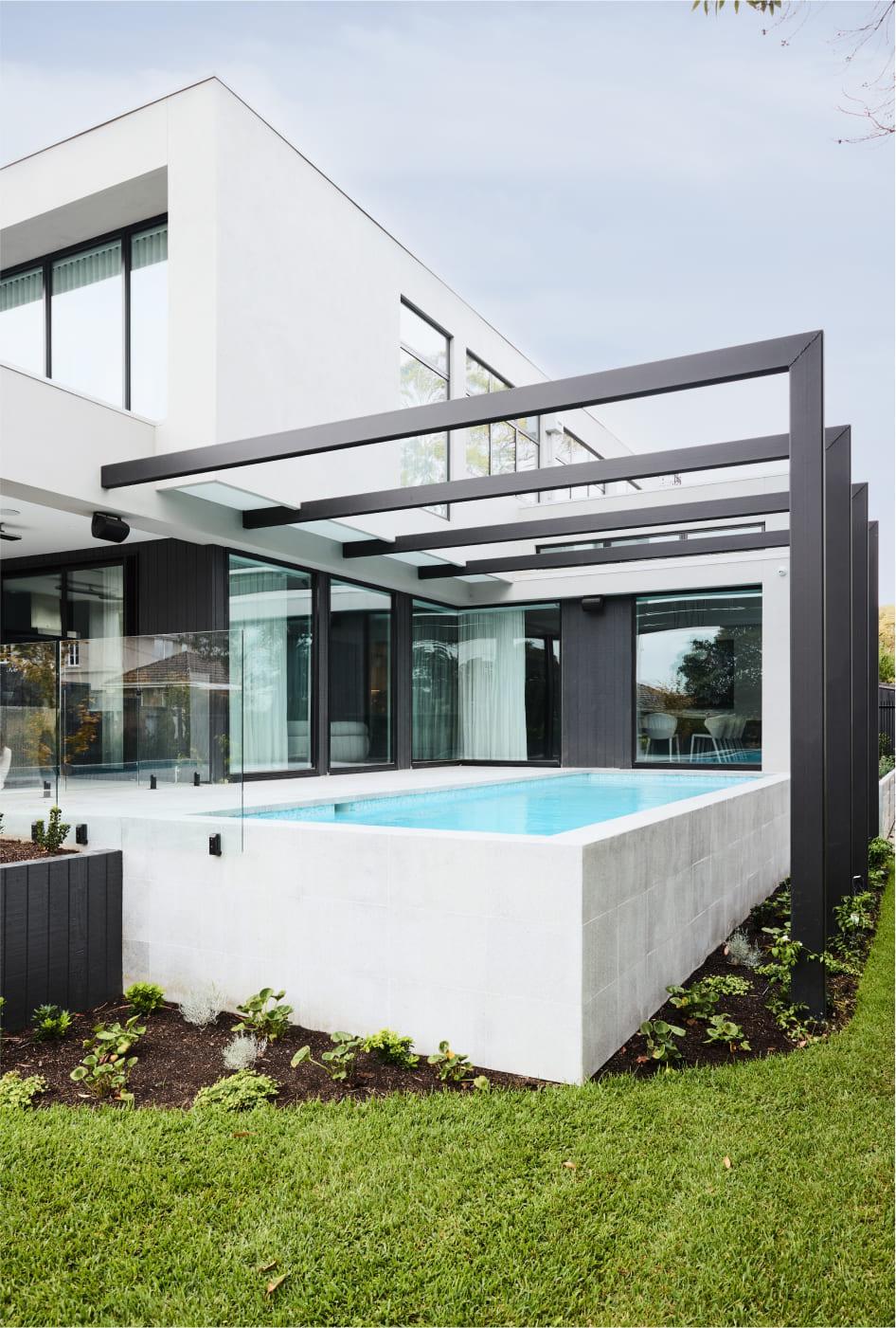 Exterior pool surrounded by verdant landscaping