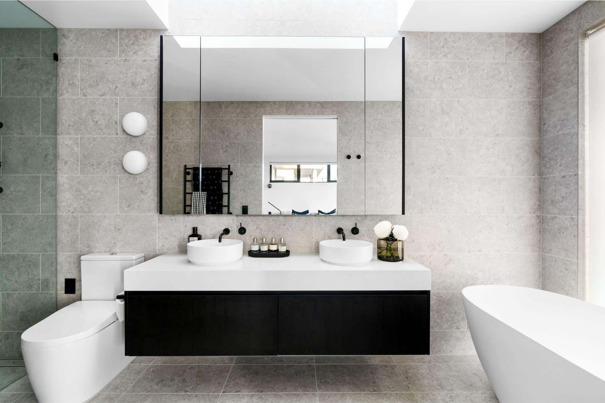 A modern bathroom with large vanity and freestanding bathtub