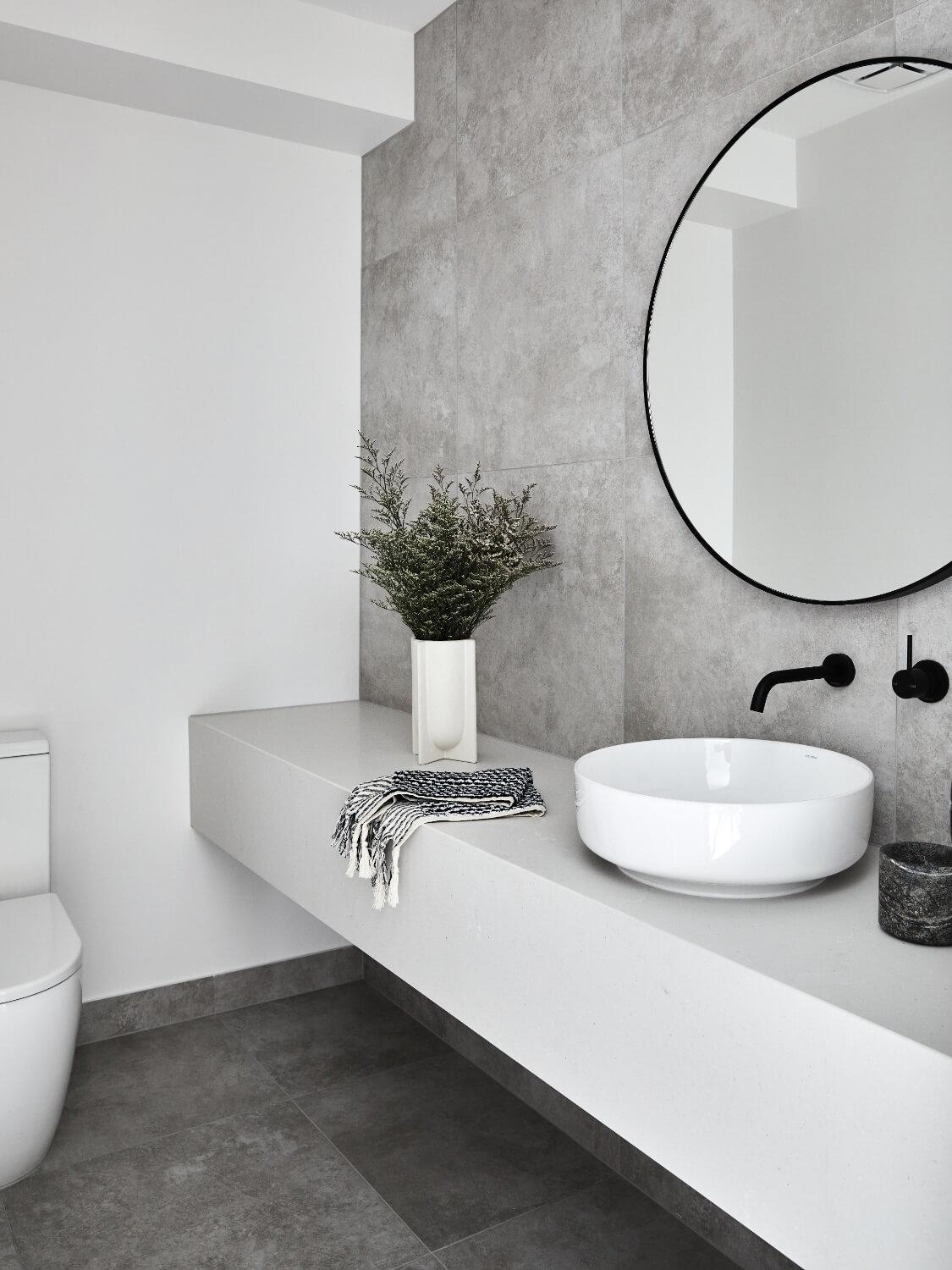 White Stone Vanity Adds Brightness To Muted Grey Tiling In Bathroom