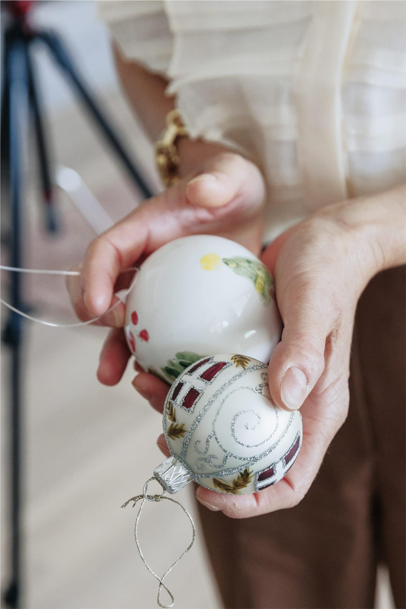 Christina Fedders holding two Christmas ornaments