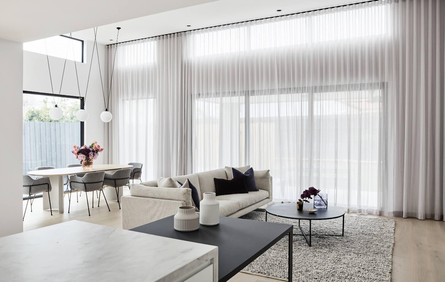Floor To Ceiling Windows And Sheer Curtains Create An Expansive Feel