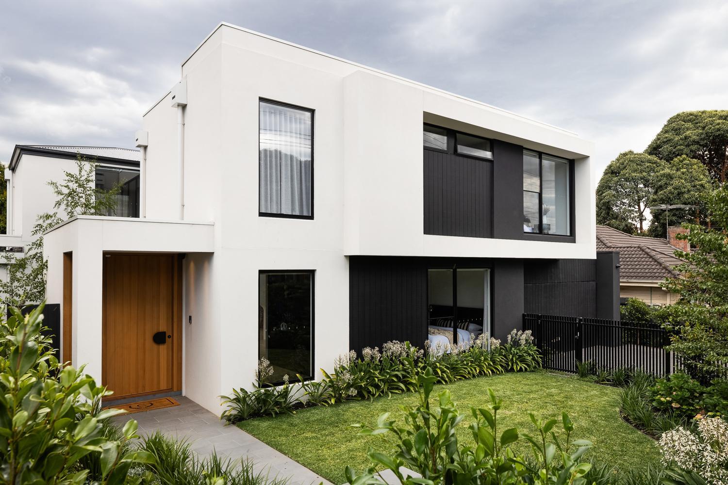 A contemporary house  external facade with a well-maintained garden and lush lawn