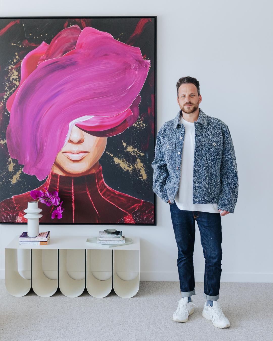 Brent Rosenberg standing next to his painting, 'the way I stare' in the Elba Display Home