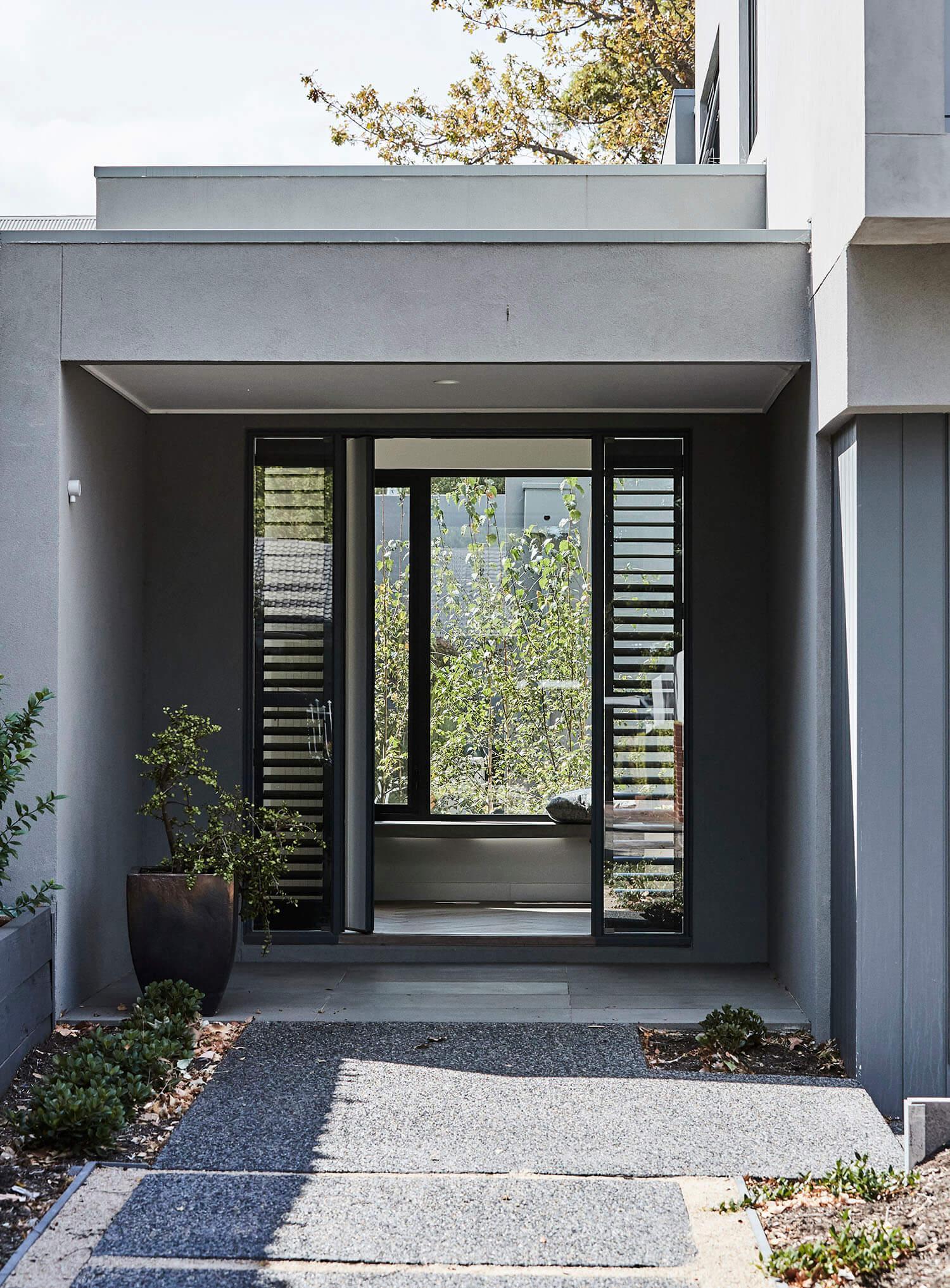 Contemporary house featuring a wide entrance and a sizable window.