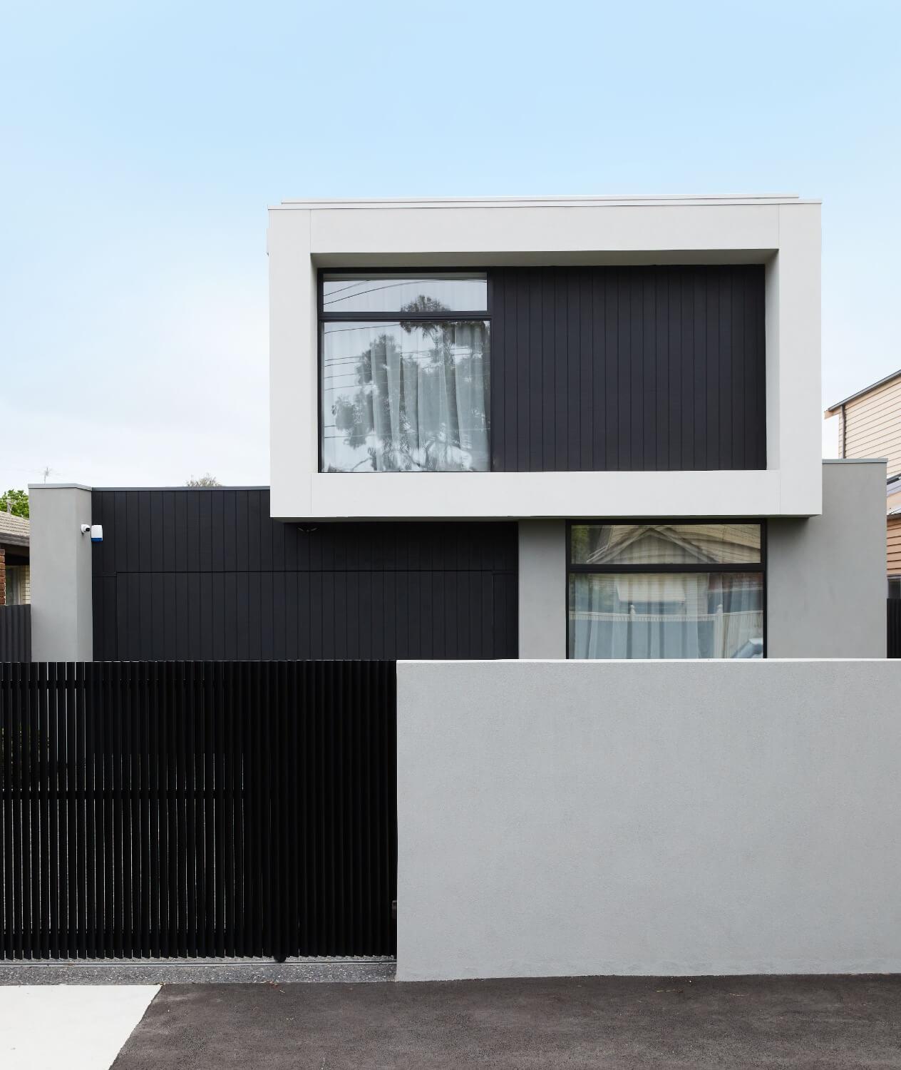 Facade Utilising Grey Render Black Cladding And Large Picture Windows 