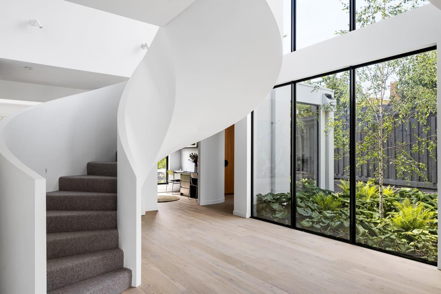 A contemporary house featuring a sculptural, spiral staircase
